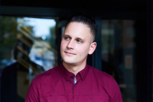 Mannelijke Trigion collega in vrijetijdskleding kijkt linksboven naar buiten