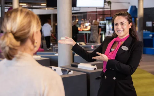 Medewerkster van Embrace wijst vrouwelijke bezoeker de weg.