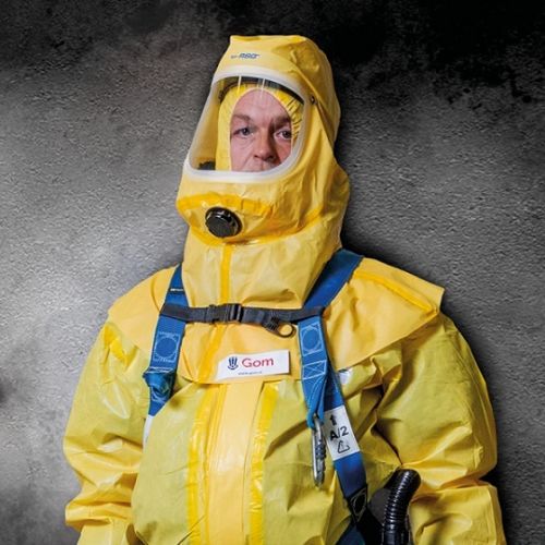 een medewerker van Gom Specialistische Reiniging in een geel beschermend pak