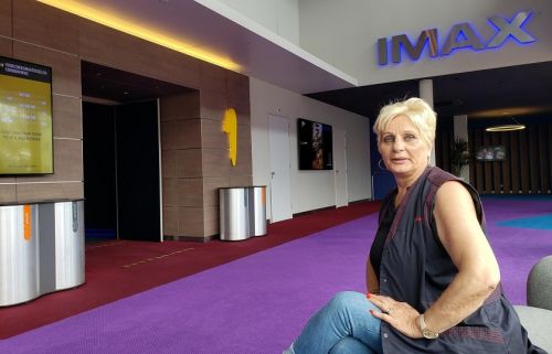 Voorvrouw Greet Huisman zit voor de IMAX zaal van de Pathé bioscoop 