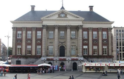 Het stadhuis van Groningen, te zien van voren met marktkramen ervoor