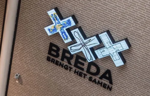 Een muur met 3 witte kruizen met tekeningen boven de woorden 'Breda brengt het samen'