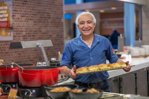 chef poseert glimlachend met een plateau broodjes