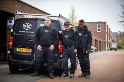 3 medewerkers Nelis Den Haag voor hun werkbusje