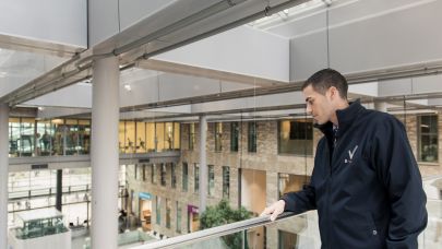 Beveiliger kijkt over balustrade naar beneden