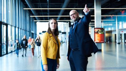 Mannelijke beveiliger in uniform wijst aan een vrouwelijke voorbijganger de weg op Jaarbeurs Utrecht. Mannelijke beveiliger in uniform wijst aan een vrouwelijke voorbijganger de weg op Jaarbeurs Utrecht.
