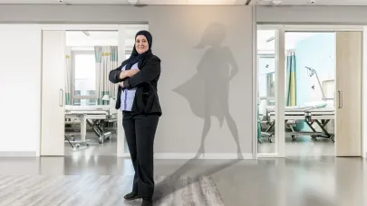 Gom Uitblinker 3-2020 Yamina Massoudi poseert in haar werkomgeving in het ziekenhuis, met als schaduw een superwoman op de muur geprojecteerd