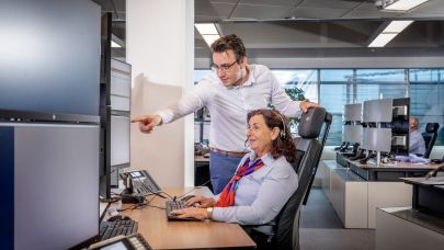 Man staat naast vrouwelijke Trigion collega die haar ondersteunt in haar werk.