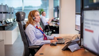 Vrouwelijke Trigion collega monitort de situatie achter haar beeldschermen. Vrouwelijke Trigion collega monitort de situatie achter haar beeldschermen.