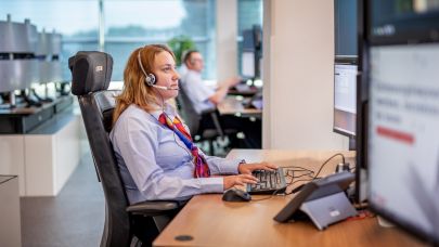 Vrouwelijke Trigion collega monitort de situatie achter haar beeldschermen.