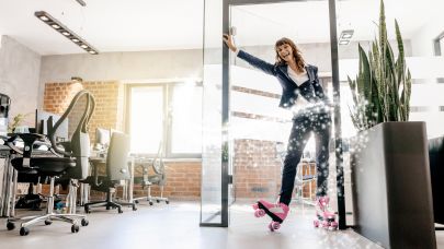 Vrouw in zakelijke kleding rolt op rollerskates binnen op kantoor.