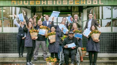 het team Wiebenga van Hanzehogeschool staat voor het pand te juichen met bloemen en hun certificaat