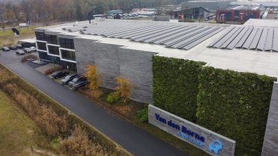 Bedrijfspand van Van den Borne vanuit de lucht gezien, waarop Sander Henten de zonnepanelen reinigt met behulp van de Solar Max