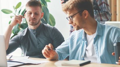 Twee mannen achter computer die de energiemonitoring bekijken