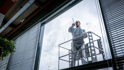 Medewerker Gom Specialistische Reiniging in hoogwerker aan het werk