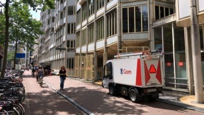 Een kleine elektrowagen in de binnenstad van Amsterdam voor de glasbewassing