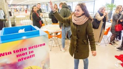 Een jonge vrouw die haar afval weggooit in de trash roulette