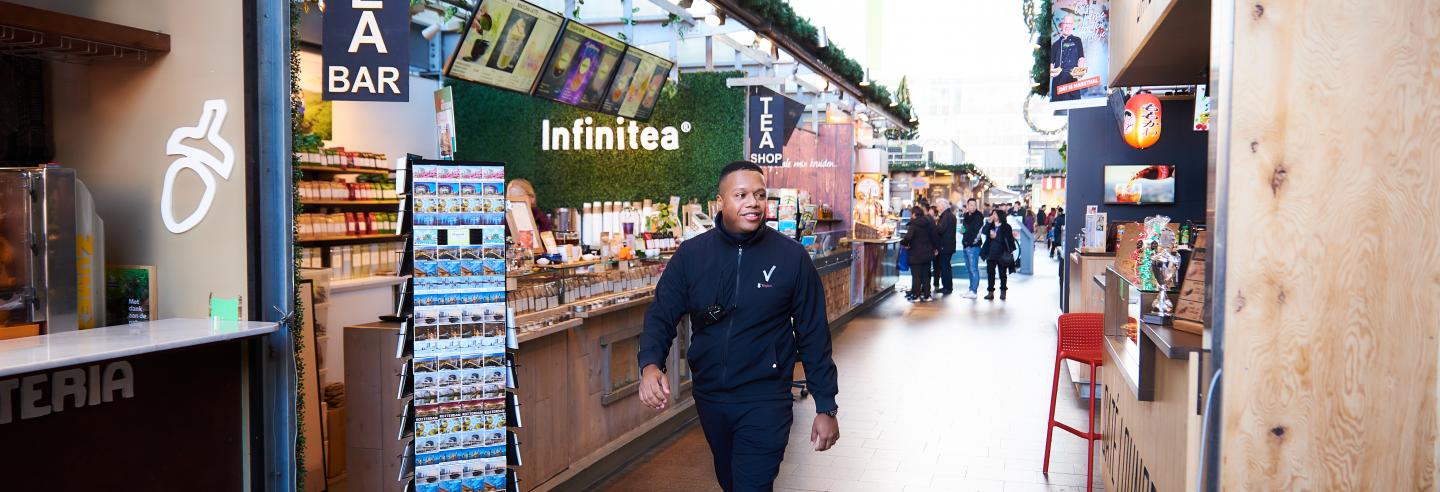 Een retailbeveiliger loopt door de winkelstraat.