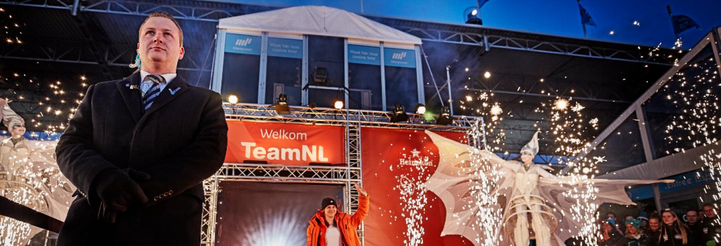Beveiliger die op wacht staat, terwijl een topsporter het podium op gaat.