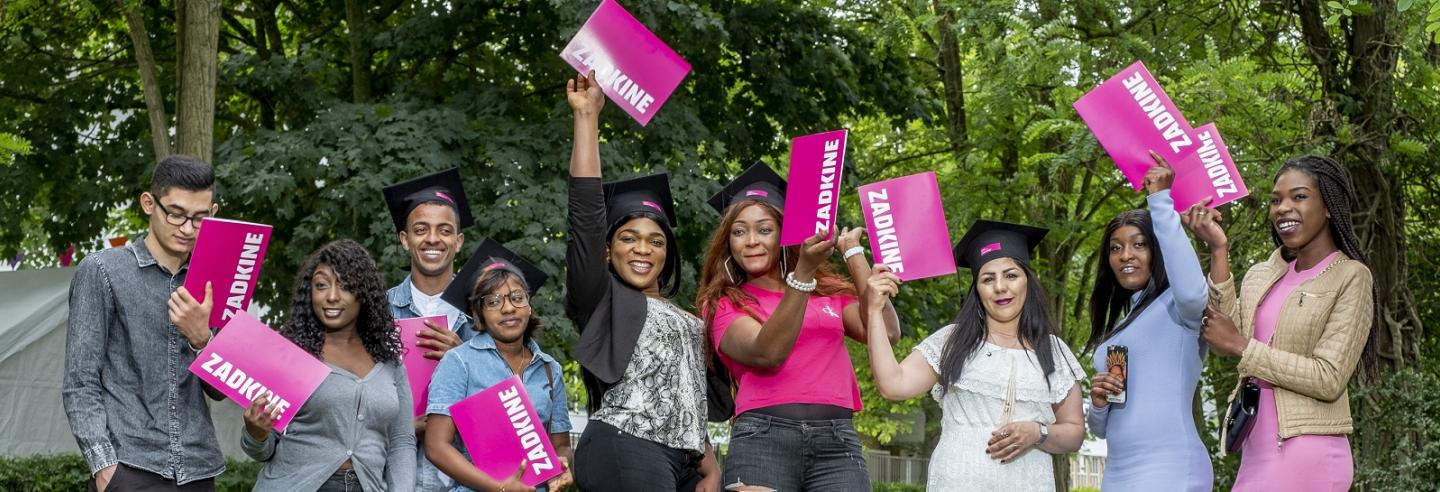 een uitbundige groep geslaagde studenten van Zadkine die hun diploma juichend omhoog houden