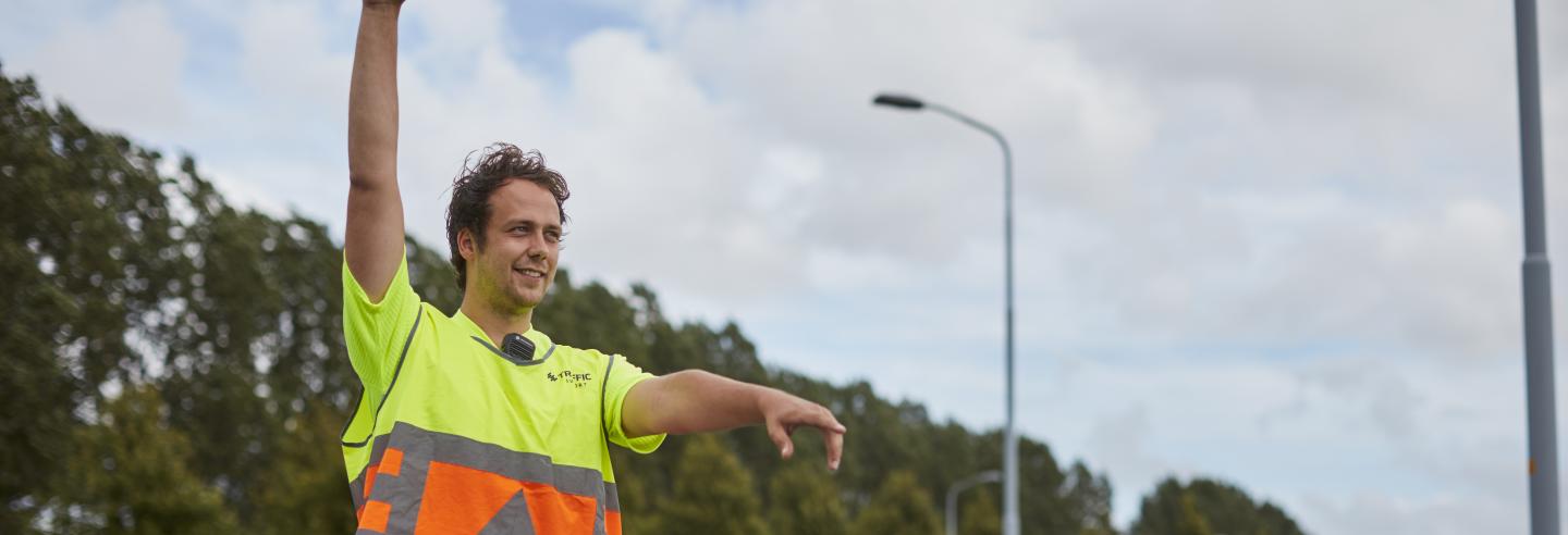 verkeersregelaar in fluor kleding met gespreide armen