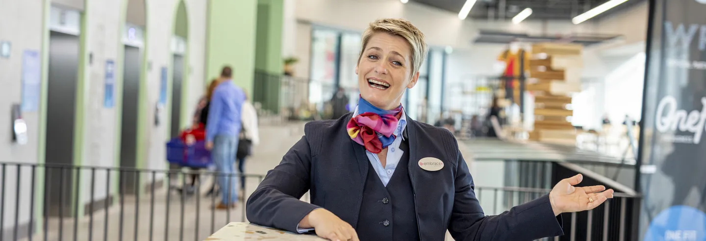 Vrouwelijke Embracemedewerkster verwelkomd de gasten.