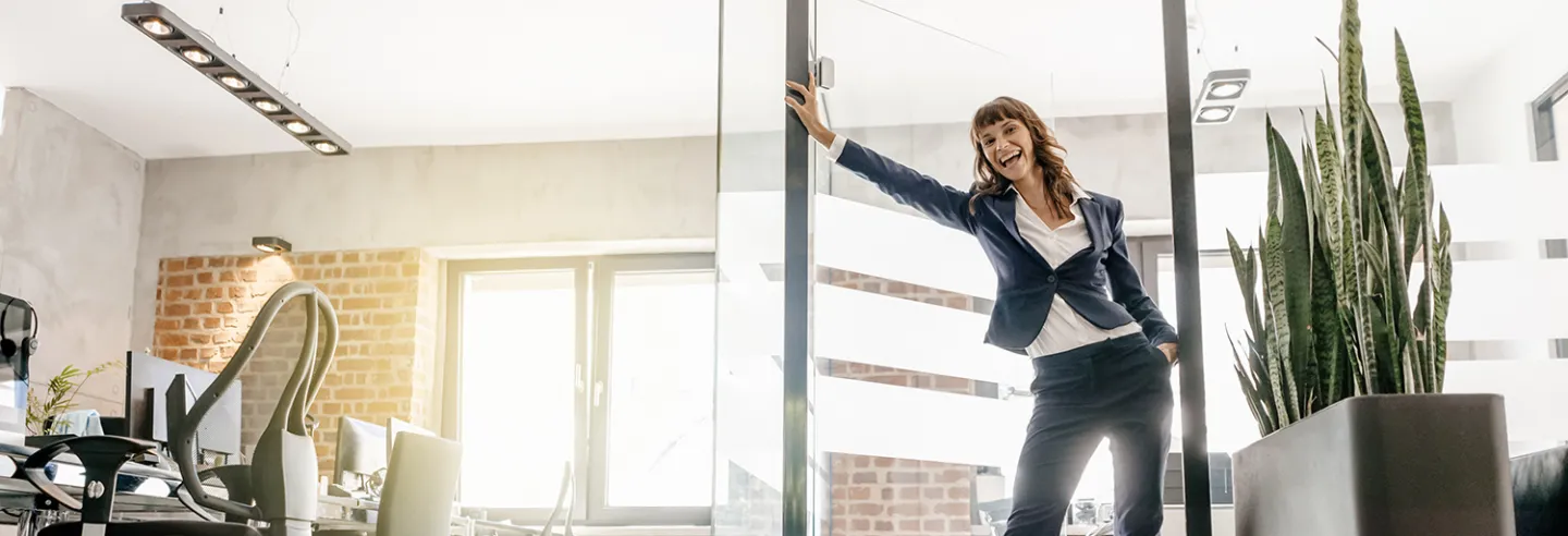 Vrouw in zakelijke kleding rolt op rollerskates binnen op kantoor.