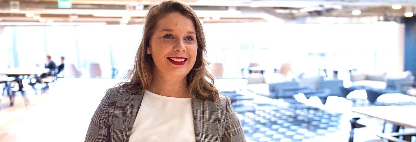 Laura Stein poseert in de aankomsthal van een bedrijfspand.