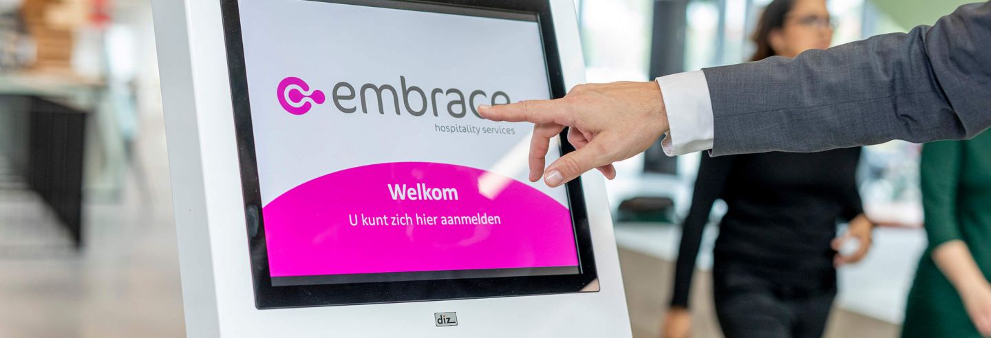 Hand reikt uit naar aanmeldpilaar waarop het logo van Embrace staat vertoond.