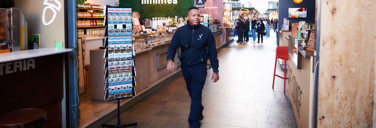 Een retailbeveiliger loopt door de winkelstraat.