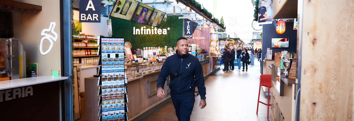 Een retailbeveiliger loopt door de winkelstraat.