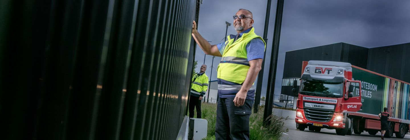 Beveiliger controleert samen met een collega het hekwerk op een bedrijventerrein