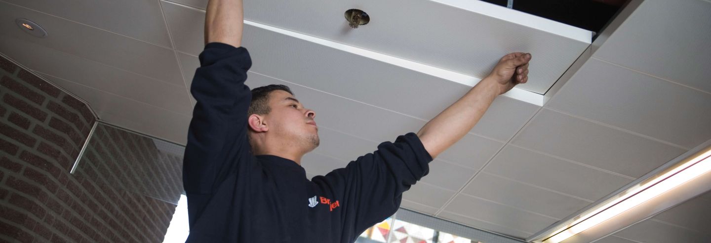 Medewerker aan het werk om sprinklers te installeren