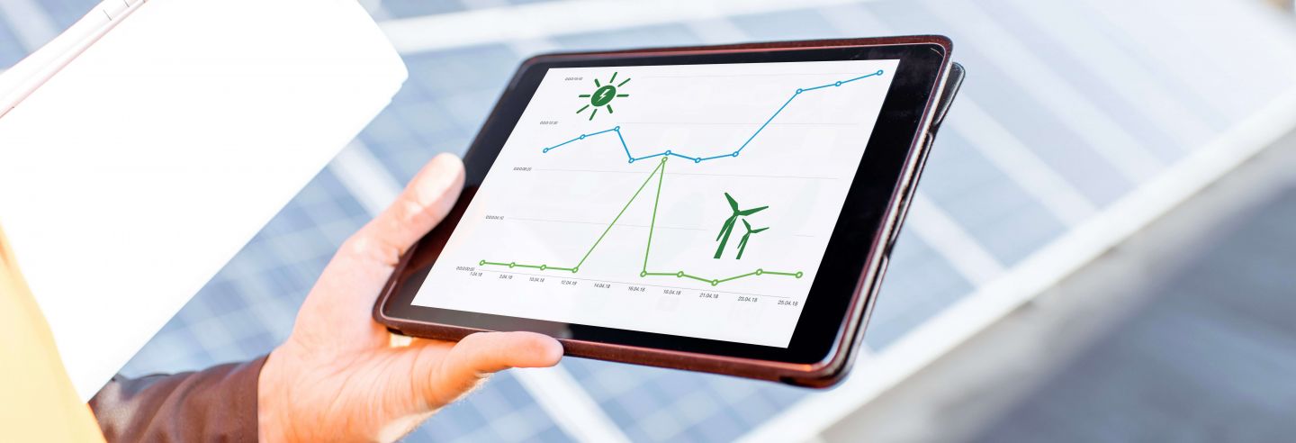 Facilitair medewerker op dak met zonnepanelen waar tablet rendement weergeeft