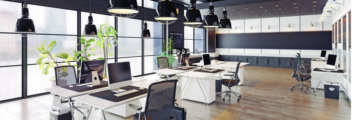 Moderne open kantoortuin met daarin ruim uit elkaar staande bureaus