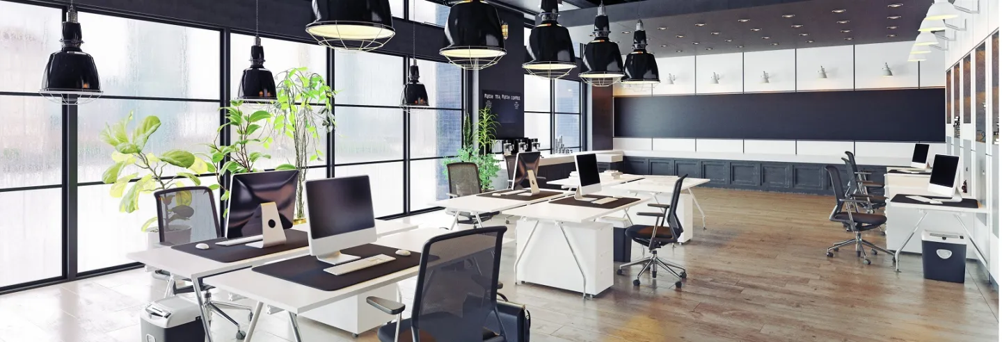 Moderne open kantoortuin met daarin ruim uit elkaar staande bureaus