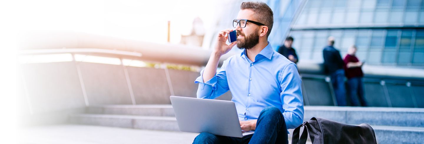 Energiemanager aan telefoon en laptop of schoot op trap voor gebouw