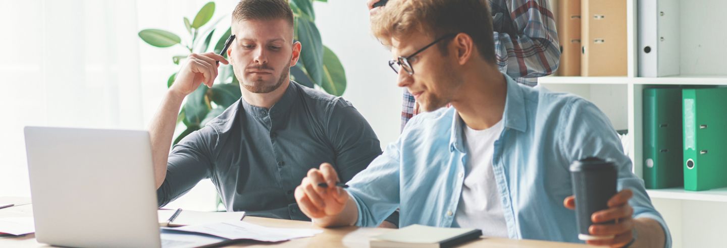 Twee mannen achter computer die de energiemonitoring bekijken