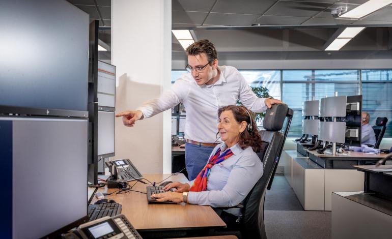 Comfortability Man staat naast vrouwelijke Trigion collega die haar ondersteunt in haar werk.