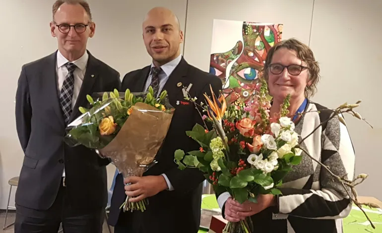 Abdel staat in zijn uniform geposeerd voor de camera met een bos bloemen.