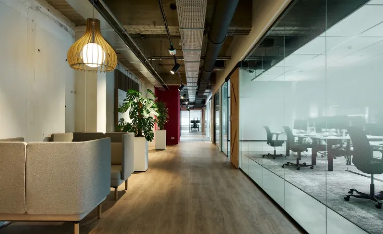 Hal in kantoor met zitjes en kantoorruimte met glaswand
