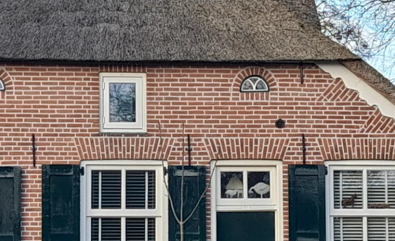 Gevel met nieuwe bovenramen en gietijzer rooster na renovatie zuiderzeestraatweg Oldebroek