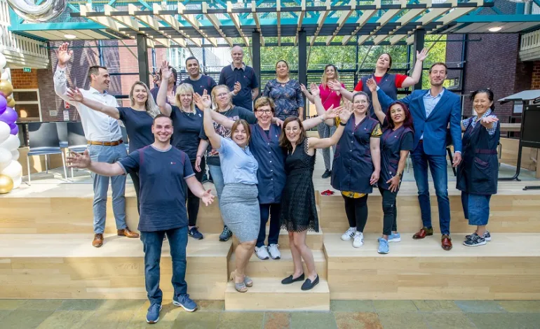 Schoonmaakster Ajsa staat samen met het team te juichen