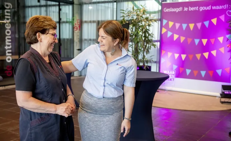 2 dames kijken elkaar lachend aan