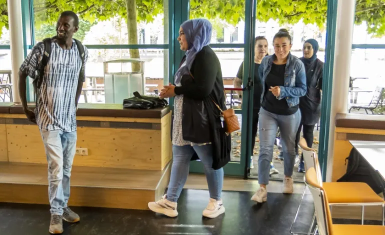 Een groepje schoonmaakmedewerkers komen de ruimte binnen