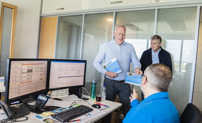 Peter Hoeijmans overhandigt de oorkonde voor Gom Uitblinker aan de winnaar, met Peter van Gogh op de achtergrond