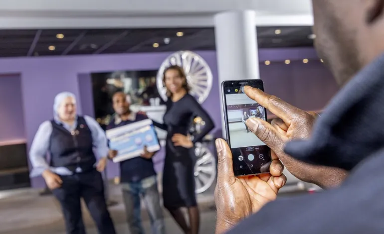 iemand neemt een foto met zijn telefoon van 3 personen