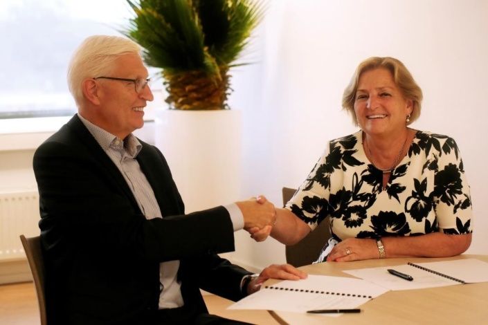 Geert van de Laar CEO Facilicom Group en Anky Romeijnders, lid college van bestuur Albeda schudden elkaars hand na contractondertekening