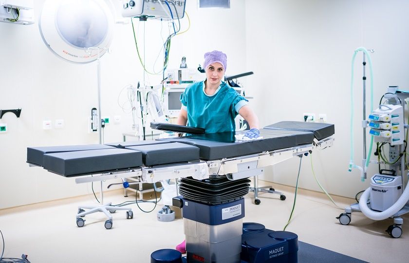 Een medewerkster van Gom Zorg staat met een doekje de operatietafel schoon te maken