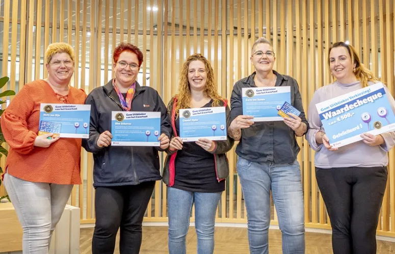 5-tal lachende schoonmaakmedewerkers die hun oorkonde van de Gom Uitblinker voor zich houden